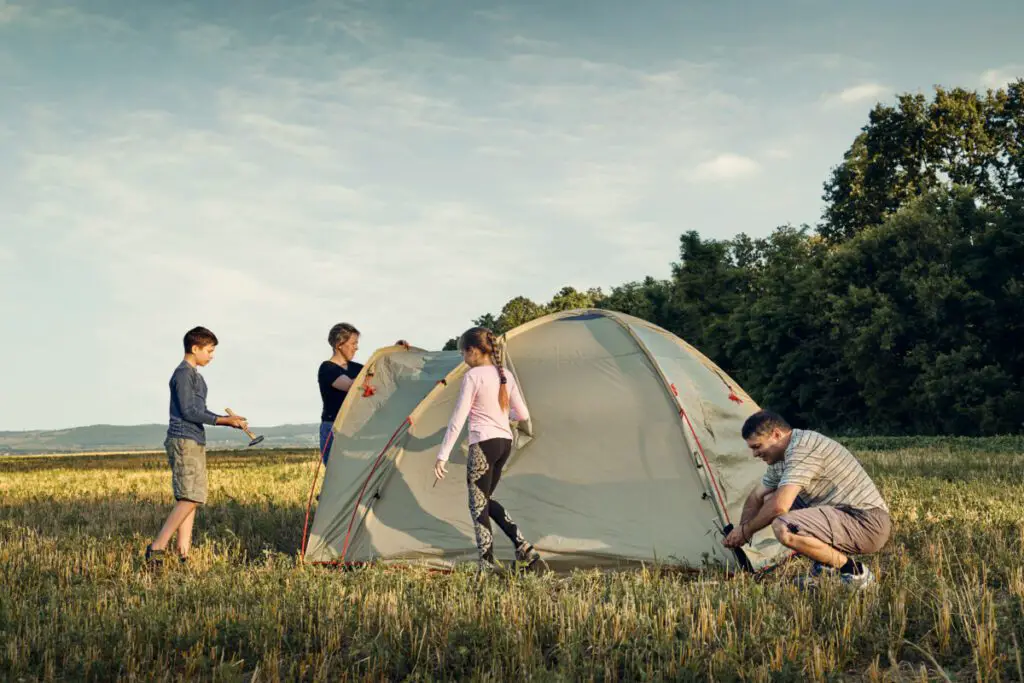 Family set up tent camp at sunset