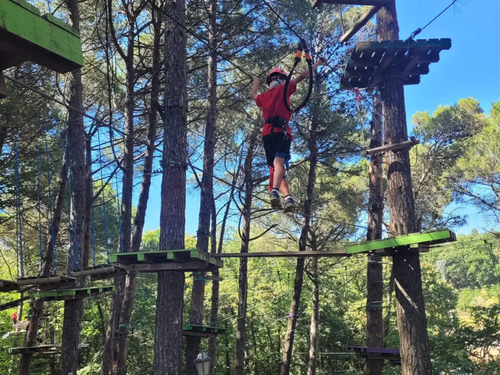 Kid climbing at an adventure park in Sicily